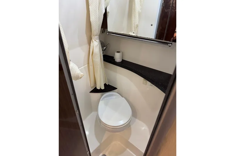 Slide: The Image of Compact bathroom in 2014 Regal 28 Express boat with toilet and curtain. - 30