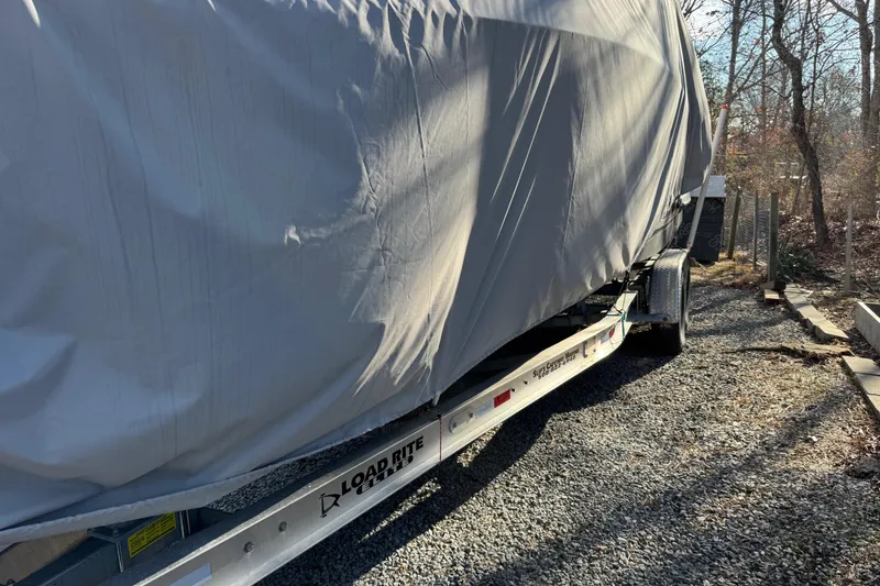 Slide: The Image of Covered 2014 Regal 28 Express boat on Load Rite trailer, parked on gravel. - 36
