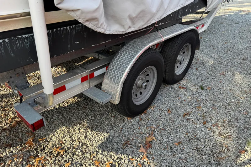 Slide: The Image of Trailer with dual wheels for 2014 Regal 28 Express boat on gravel surface. - 38