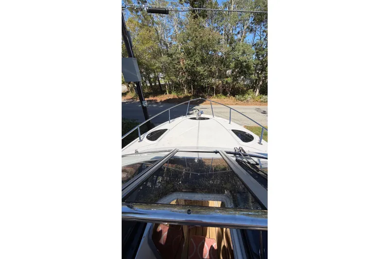 Slide: The Image of 2014 Regal 28 Express boat deck view with trees in the background. - 5