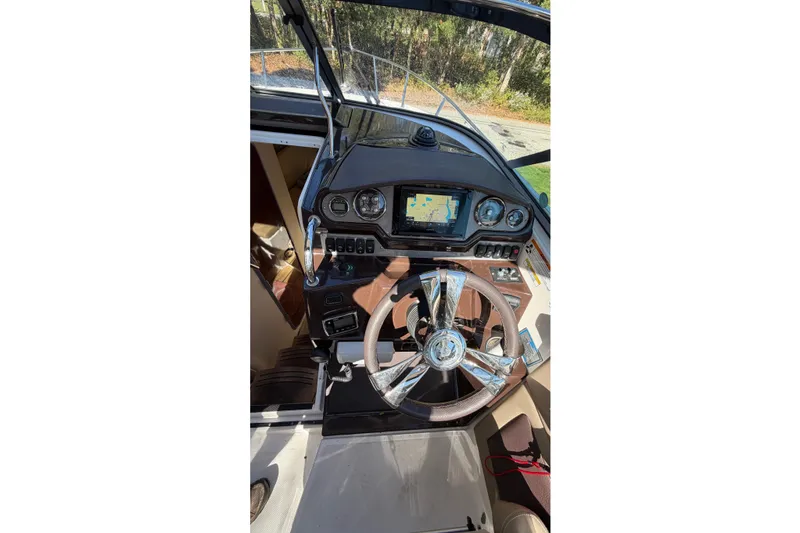 Slide: The Image of 2014 Regal 28 Express boat dashboard with steering wheel and navigation system. - 6