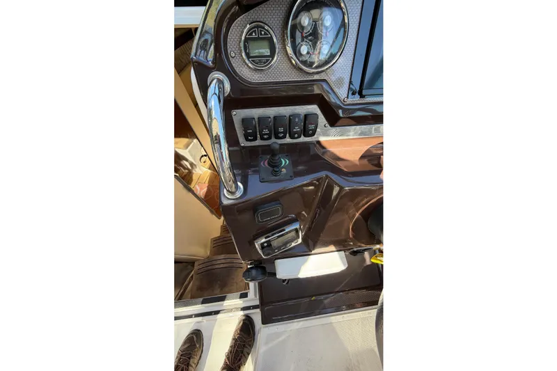 Slide: The Image of Control panel of a 2014 Regal 28 Express boat with steering wheel and switches. - 7