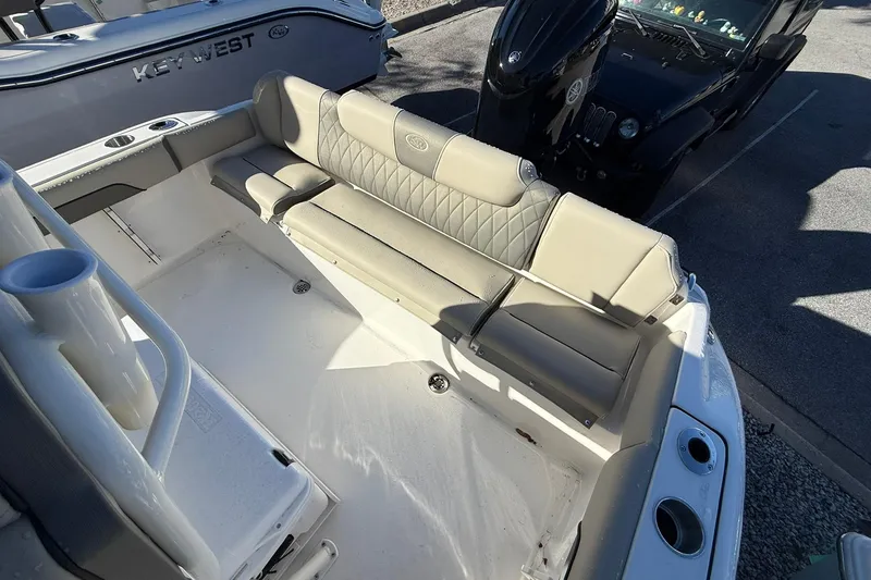 Slide: The Image of 2026 Key West 219 FS boat interior with beige seating and cup holders. - 10