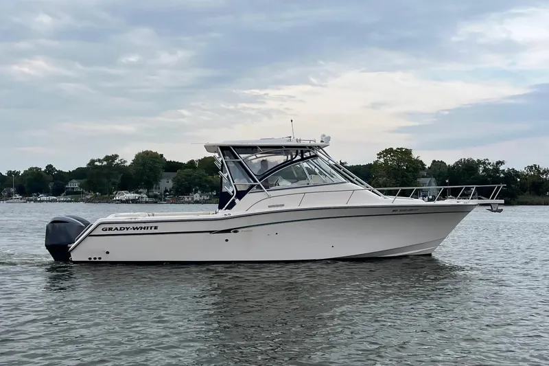 The Image of 2013 Grady-White Express 330 boat on calm water, overcast sky background. - 0