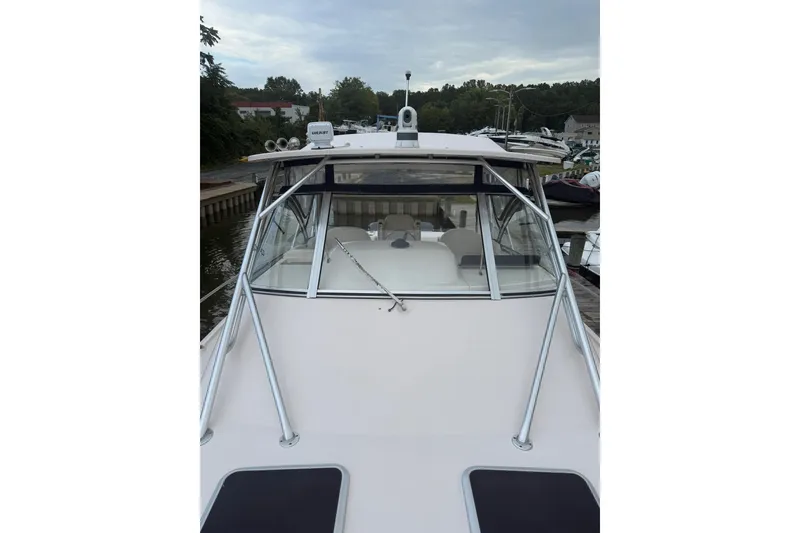 Slide: The Image of 2013 Grady-White Express 330 boat docked, showcasing sleek design and spacious deck. - 14