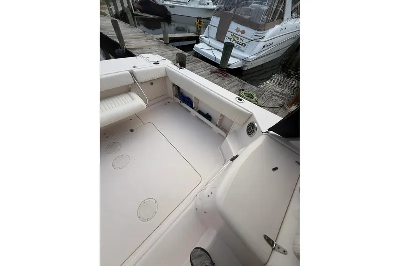 Slide: The Image of 2013 Grady-White Express 330 boat interior at dock, featuring seating and storage. - 2