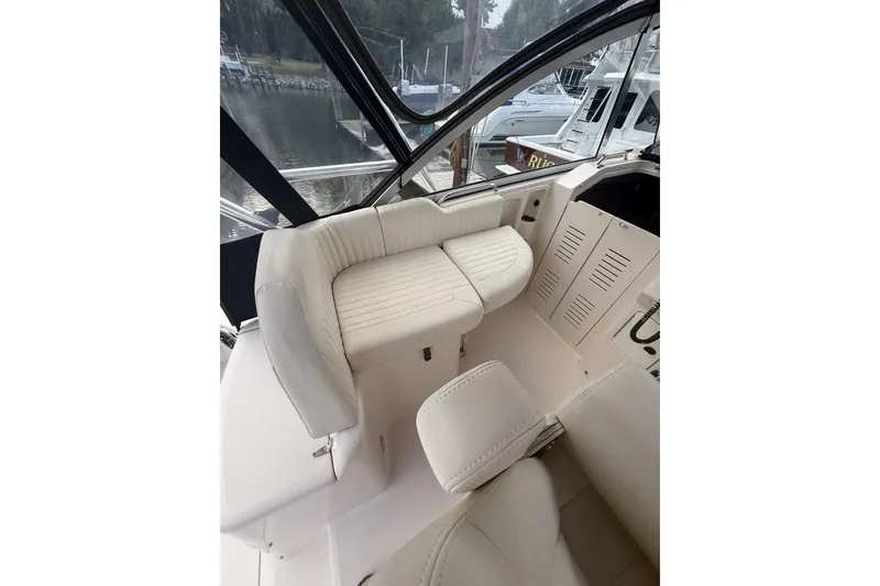 Slide: The Image of 2013 Grady-White Express 330 boat interior with white seating and dashboard view. - 4