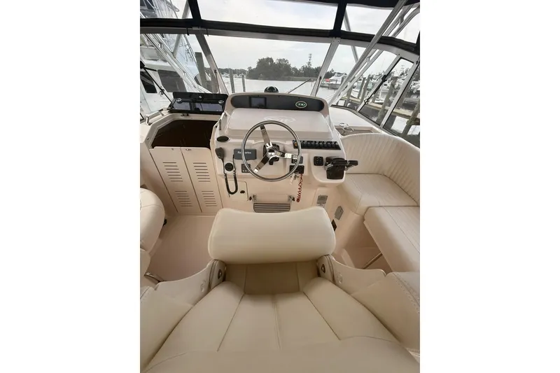 Slide: The Image of 2013 Grady-White Express 330 helm with steering wheel and controls, docked at marina. - 6