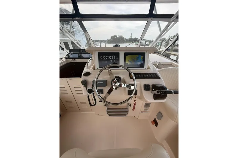 Slide: The Image of 2013 Grady-White Express 330 helm with navigation screens and steering wheel. - 7
