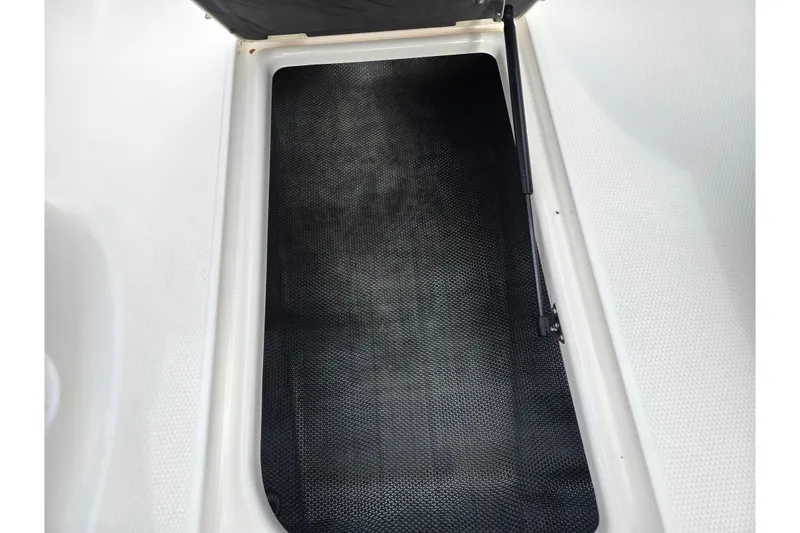 Slide: The Image of 2015 Chaparral Vortex 223 VRX storage compartment with black mat and hydraulic lift. - 14
