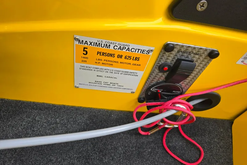 Slide: The Image of 2016 Bass Cat Caracal boat capacity label and control panel, yellow interior. - 14