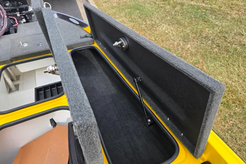 Slide: The Image of 2016 Bass Cat Caracal boat storage compartment with open lid, showcasing interior details. - 18
