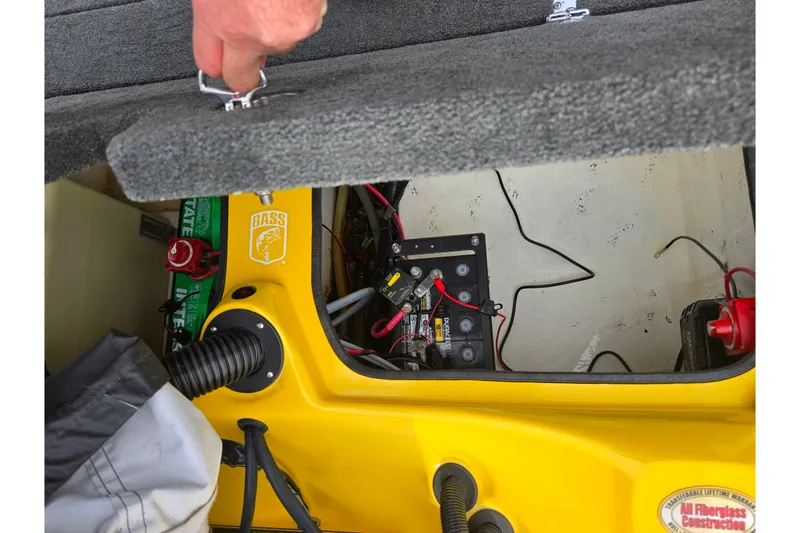 Slide: The Image of 2016 Bass Cat Caracal boat battery compartment with wiring and storage access. - 26