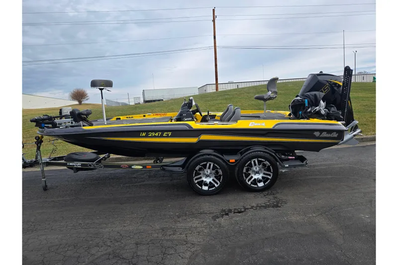 Slide: The Image of 2016 Bass Cat Caracal boat in yellow and black, parked on a trailer. - 4