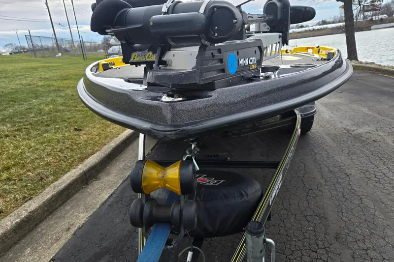 Slide: The Image of 2016 Bass Cat Caracal boat with Minn Kota motor on trailer by a lake. - 6