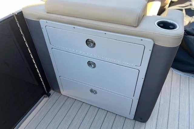 Slide: The Image of 2026 Godfrey Monaco 255 SFLC boat interior with storage drawers and cup holder. - 16