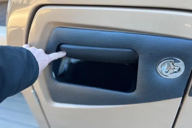 Slide: The Image of Hand opening storage compartment on 2026 Godfrey Monaco 255 SFLC boat. - 19