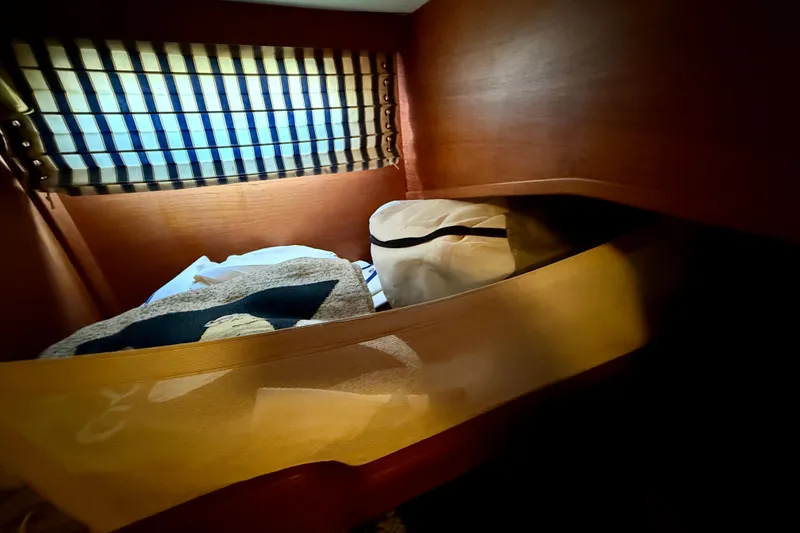 Slide: The Image of Cozy cabin interior of 1986 Nauticat 43 sailboat with striped window curtain. - 43