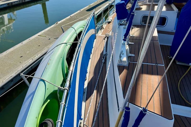 Slide: The Image of 1986 Nauticat 43 sailboat deck with green kayak, docked at marina. - 55