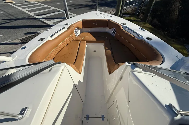 Slide: The Image of 2026 Key West 239 DFS boat with tan seating and white deck, parked on roadside. - 5