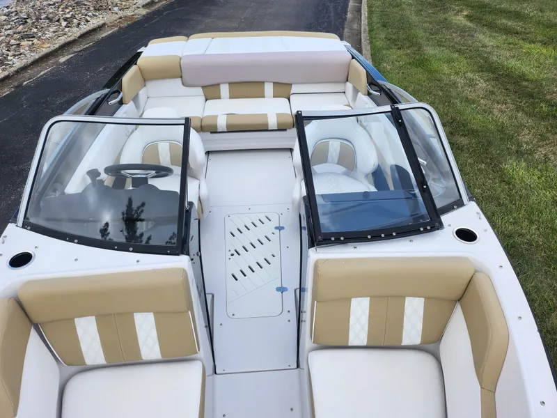 Slide: The Image of 2016 Glastron GT 205 boat interior with beige and white seating, windshield, and steering wheel. - 19