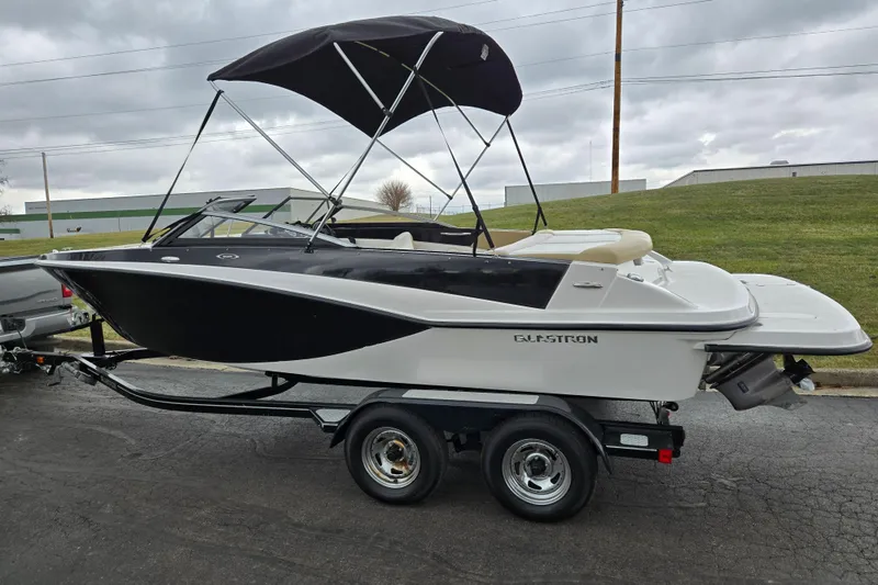 Slide: The Image of 2016 Glastron GT 205 boat on trailer with canopy, parked outdoors. - 4