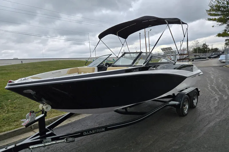Slide: The Image of 2016 Glastron GT 205 boat on trailer, black and white design, overcast sky background. - 5