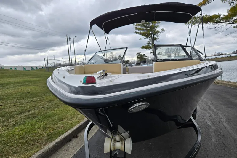 Slide: The Image of 2016 Glastron GT 205 boat with canopy on trailer, parked near a lake. - 6