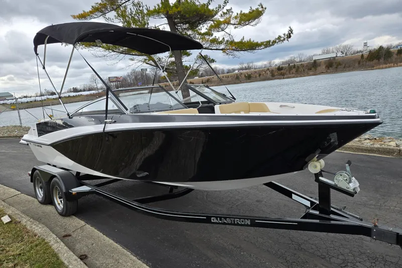 Slide: The Image of 2016 Glastron GT 205 boat on trailer by a lakeside, under cloudy skies. - 8