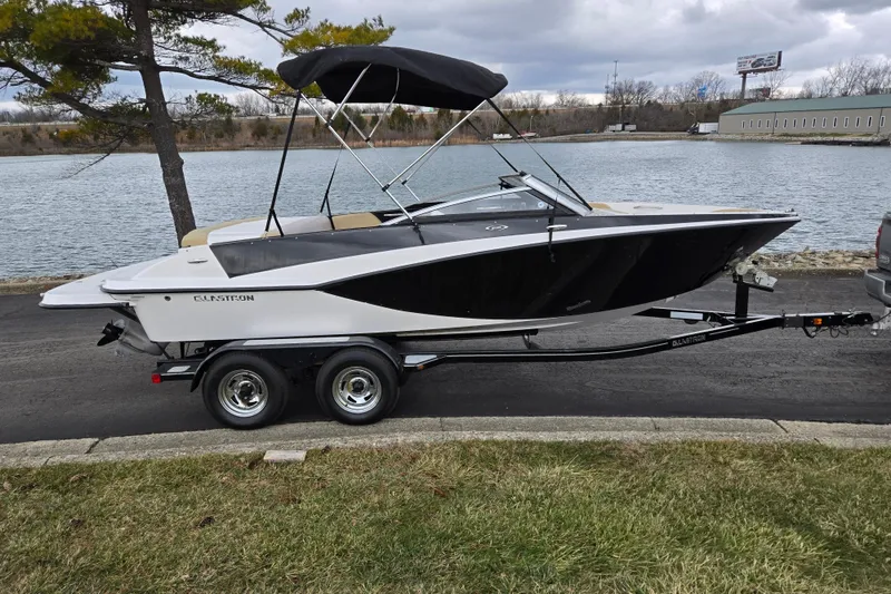 Slide: The Image of 2016 Glastron GT 205 boat on trailer by a lake, under cloudy sky. - 9