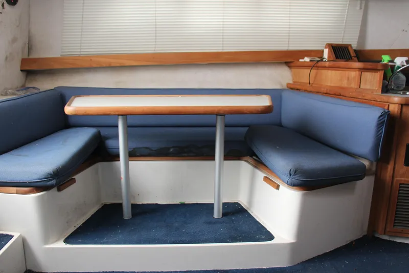 Slide: The Image of Interior of 1995 Carver 330 Mariner with blue cushioned seating and wooden table. - 25