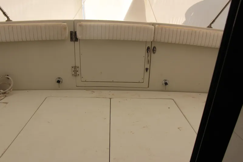 Slide: The Image of 1995 Carver 330 Mariner boat interior with cushioned seating and storage compartment. - 27