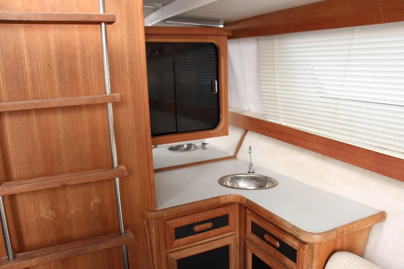 Slide: The Image of Interior of 1995 Carver 330 Mariner yacht with wooden cabinetry and compact sink. - 29
