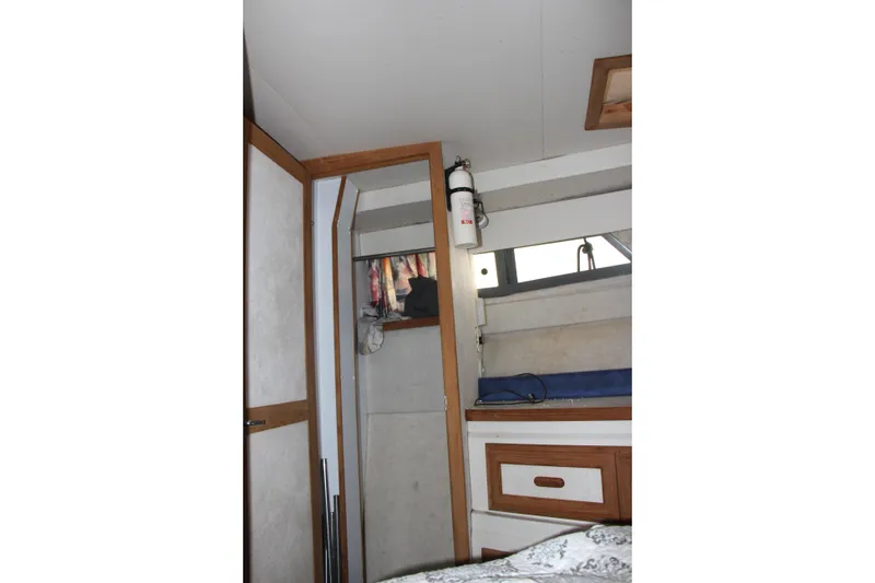Slide: The Image of Interior of 1995 Carver 330 Mariner boat with storage and fire extinguisher. - 46