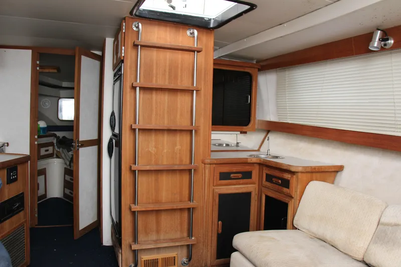 Slide: The Image of Interior of 1995 Carver 330 Mariner yacht with wood cabinetry and seating area. - 32