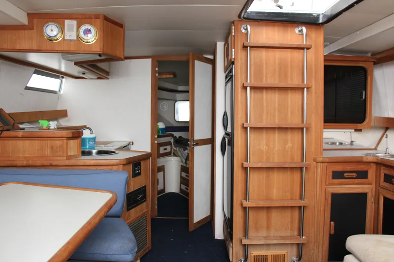 Slide: The Image of Interior of 1995 Carver 330 Mariner yacht, featuring wood cabinetry and compact kitchen area. - 33