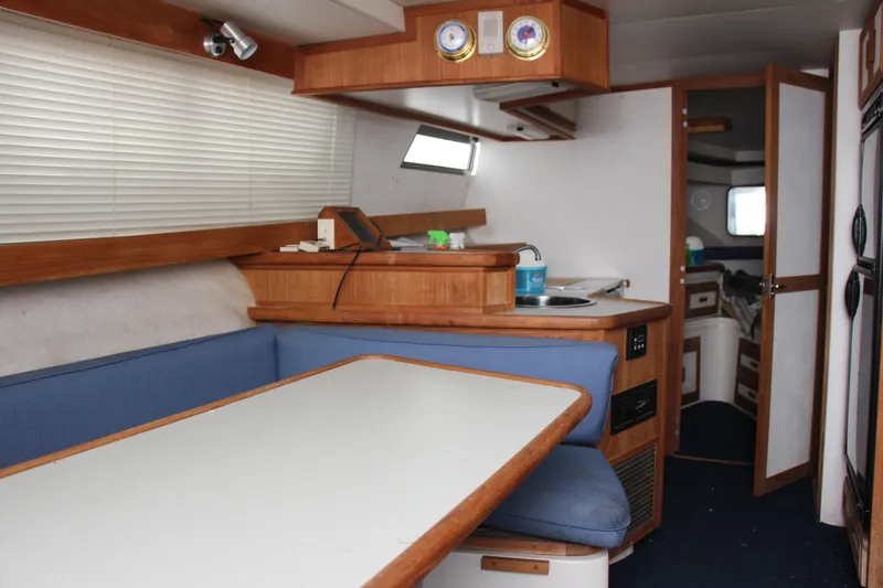 Slide: The Image of Interior of 1995 Carver 330 Mariner yacht with dining area and kitchenette. - 34