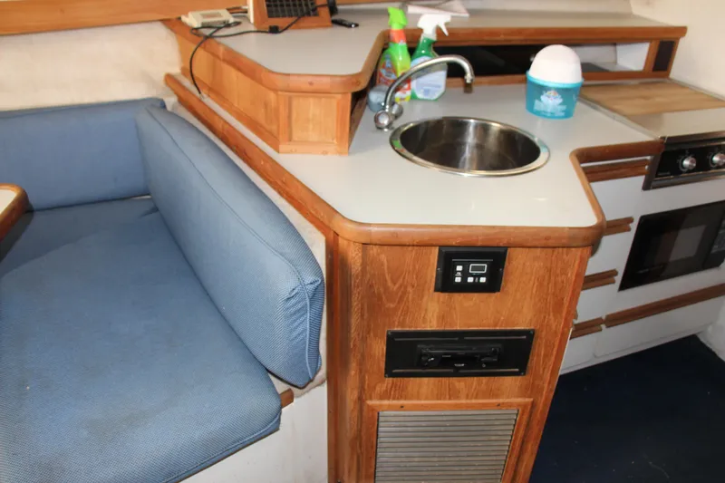 Slide: The Image of 1995 Carver 330 Mariner interior with kitchenette, sink, and blue seating. - 35
