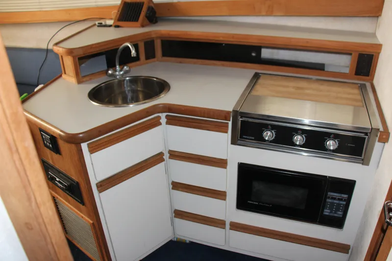 Slide: The Image of 1995 Carver 330 Mariner kitchen with sink, stove, and microwave. - 37
