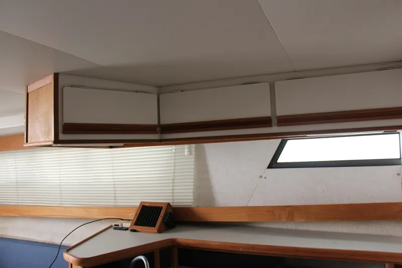 Slide: The Image of Interior of a 1995 Carver 330 Mariner boat with cabinets and window blinds. - 39