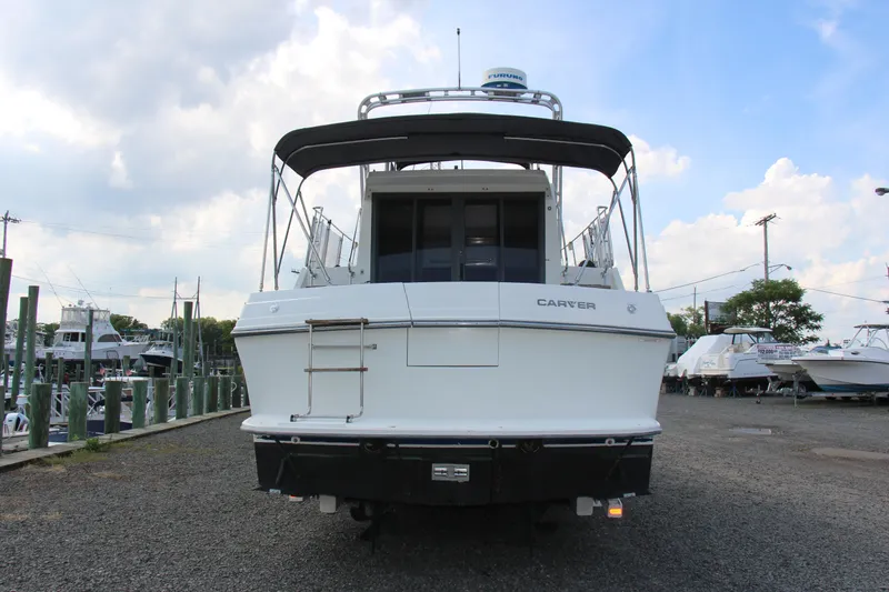 Slide: The Image of 1995 Carver 330 Mariner boat docked, rear view under cloudy sky. - 4