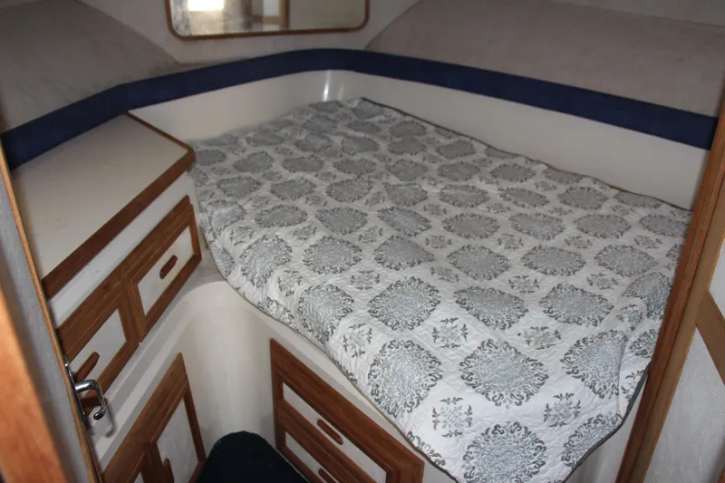 Slide: The Image of 1995 Carver 330 Mariner cabin interior with bed and wooden storage cabinets. - 43