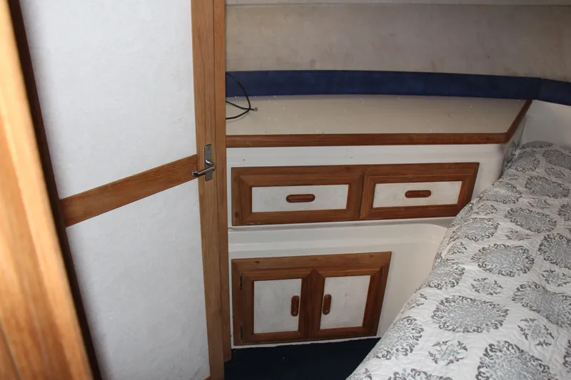 Slide: The Image of 1995 Carver 330 Mariner cabin interior with wood accents and patterned bedding. - 45