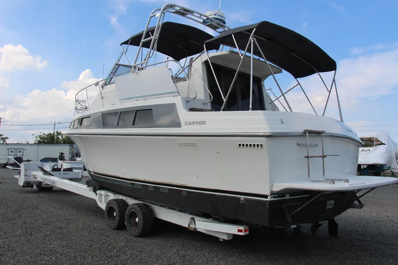 Slide: The Image of 1995 Carver 330 Mariner boat on trailer, featuring sleek design and spacious deck. - 5
