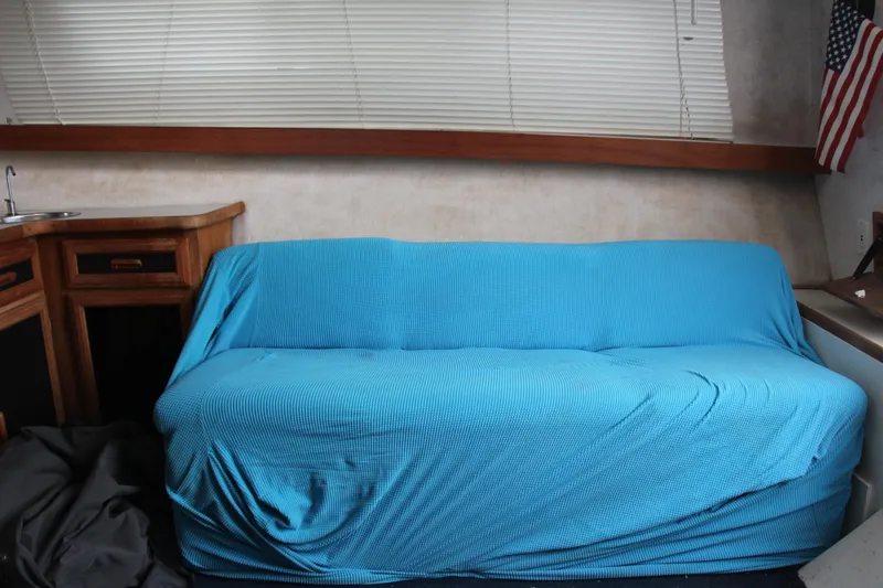 Slide: The Image of Interior of 1995 Carver 330 Mariner with blue-covered sofa and wooden cabinetry. - 50