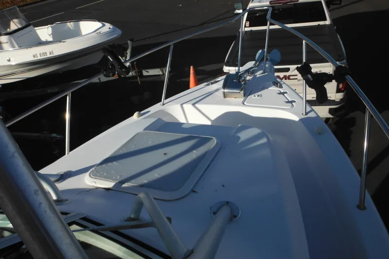 Slide: The Image of 2000 Pro-Line 23 Walkaround boat on trailer, parked near a white GMC truck. - 17