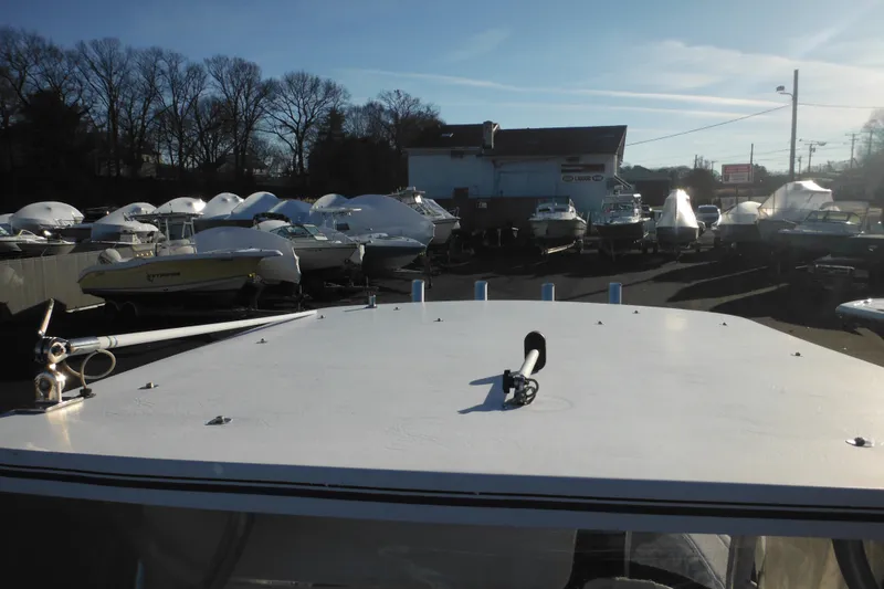 Slide: The Image of 2000 Pro-Line 23 Walkaround boat in a marina with covered boats. - 22