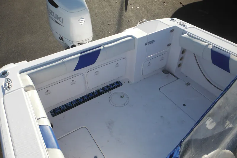 Slide: The Image of 2000 Pro-Line 23 Walkaround boat interior with Suzuki outboard motor, featuring storage compartments. - 23