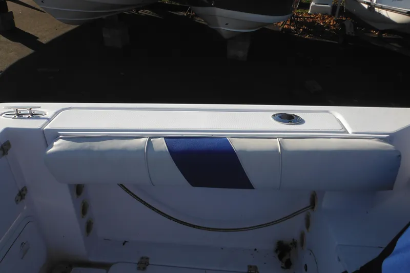 Slide: The Image of 2000 Pro-Line 23 Walkaround boat interior with cushioned seating and storage compartment. - 25