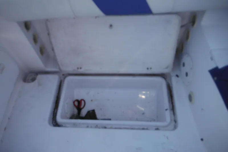 Slide: The Image of Open storage compartment on 2000 Pro-Line 23 Walkaround boat with scissors inside. - 30